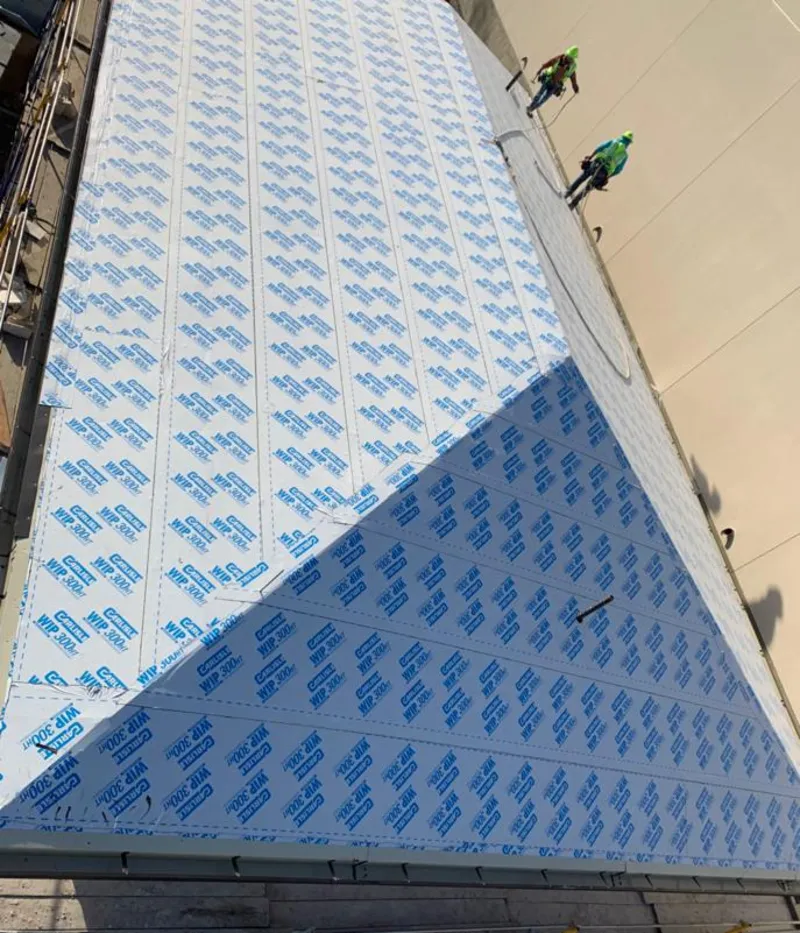 Professional roofers installing underlayment on a metal roof in Lake Tapps